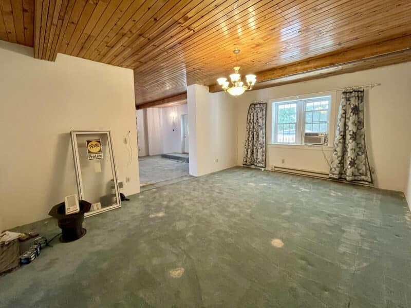 Dining room with chandelier, wood ceiling, and large window.