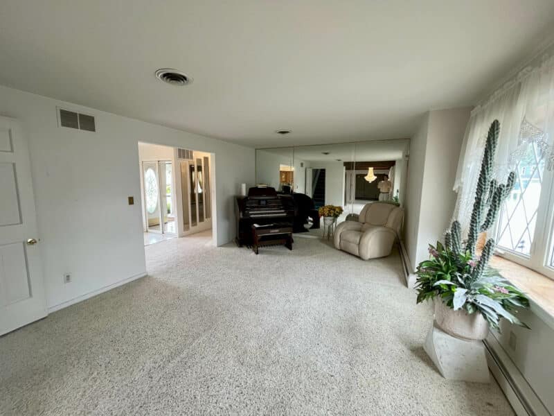 Living room with carpet and large front windows in Dundalk Farms rancher.