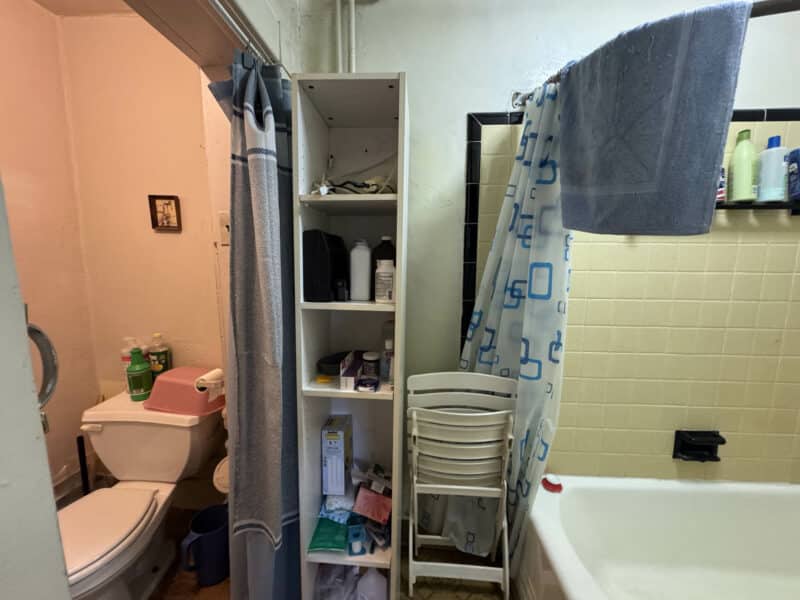 Full bathroom with bathtub, tiled walls, vanity sink, and shelving