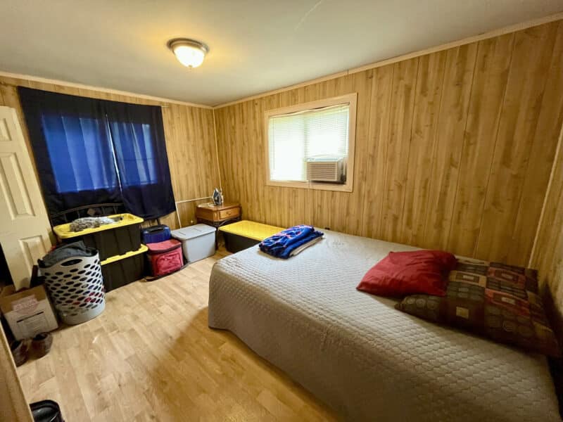 Second bedroom with single bed, dresser, and storage bins
