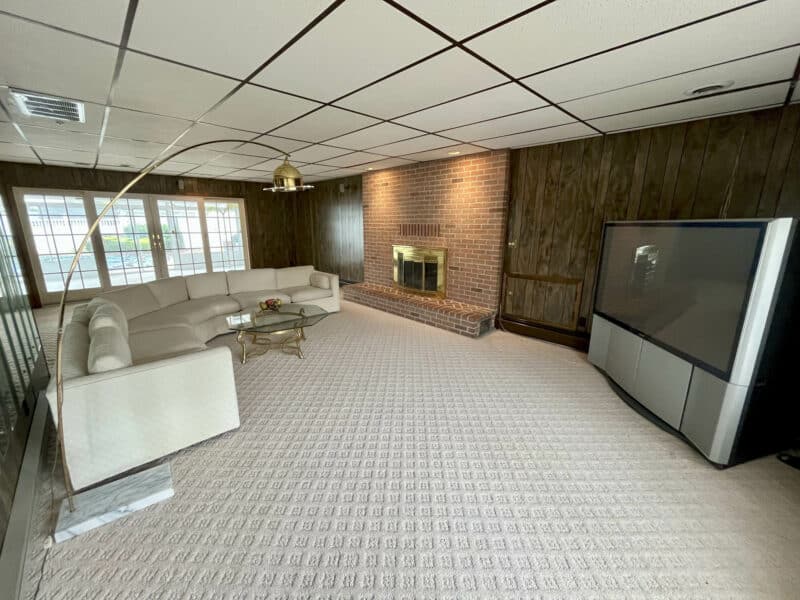 Family room with brick fireplace and pool access at 7245 Meadow Lane.