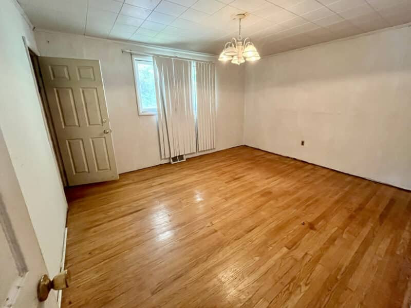Bedroom with hardwood floors, chandelier, and closet.