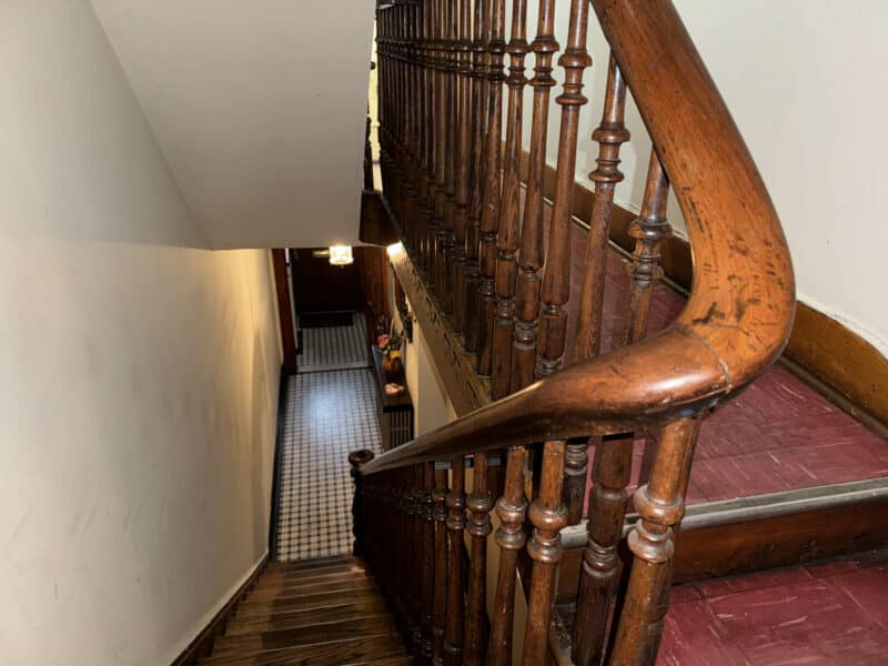 Stairway with detailed wooden railing and curved banister