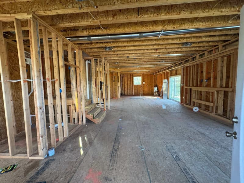 Unfinished lower level space with exposed framing, subflooring, and mechanical rough-in.