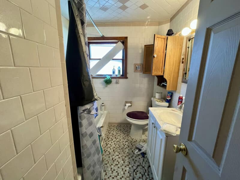 Bathroom with tile flooring, vanity, and shower-tub area.