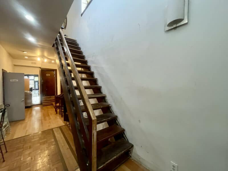 Wooden staircase leading to upper-level space.