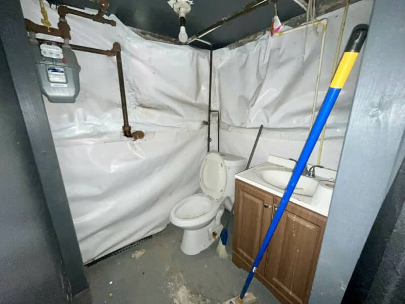 Basement half bathroom with vanity and utility meters.