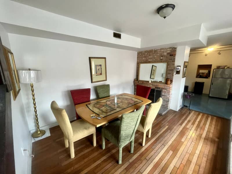 Dining room with wood flooring, exposed brick, and modern lighting.