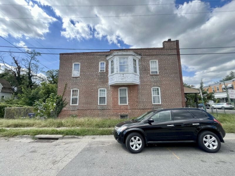 Side exterior view of brick townhome with bay window.