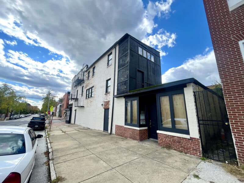 Rear corner perspective of the building showing brick construction and windows.