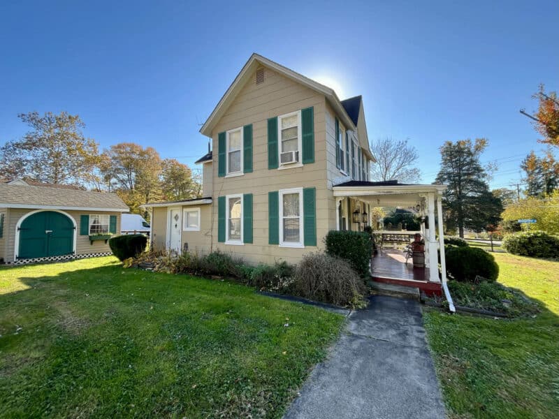 Front walkway and porch of farmhouse at 1207 Joppa Road, Joppa, MD, featuring covered porch and landscaped entry.