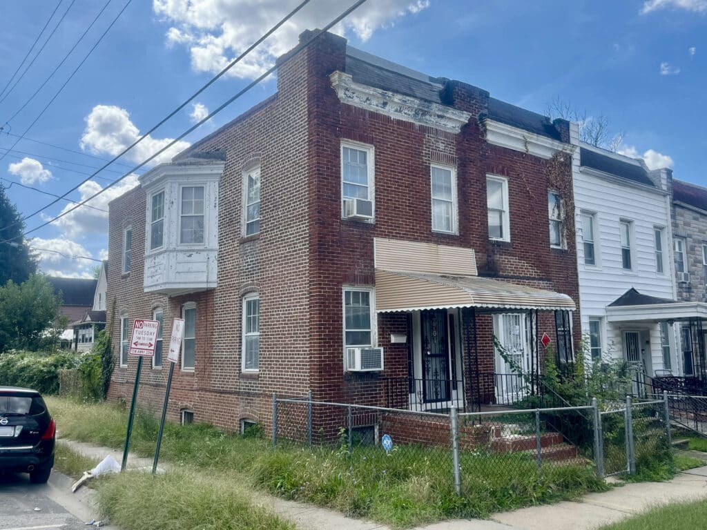 Brick end-of-group townhome at 2701 Baker Street with front porch and fenced yard.