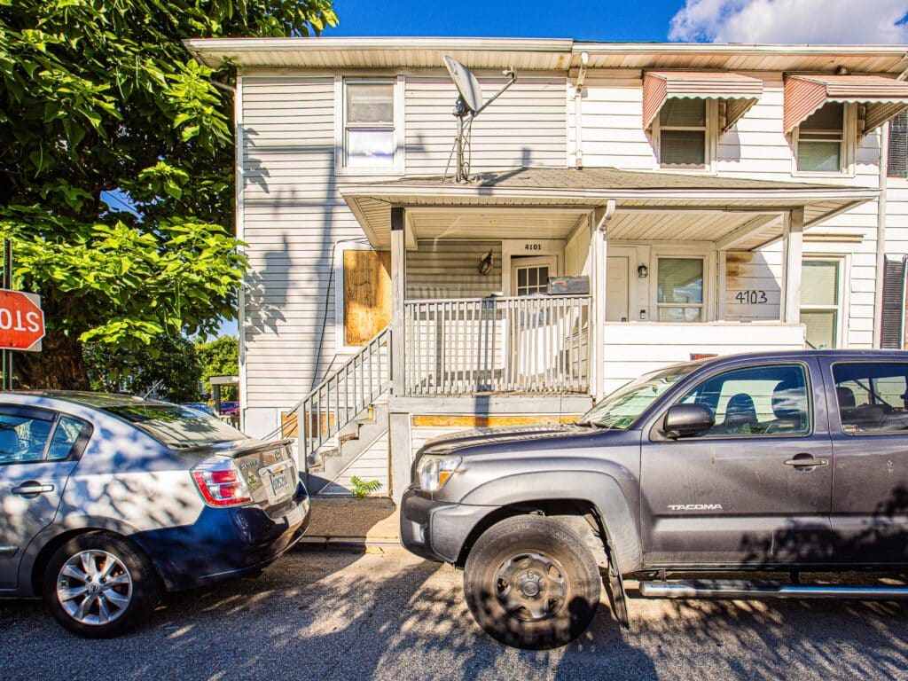 End-of-group townhome with covered front porch and siding exterior on residential street.