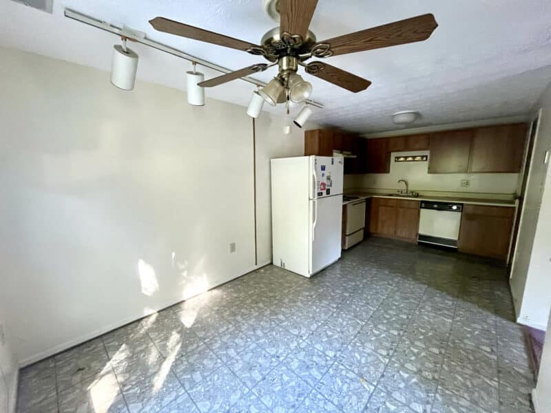 Eat-in kitchen with ceiling fan, laminate cabinets, and vinyl flooring.