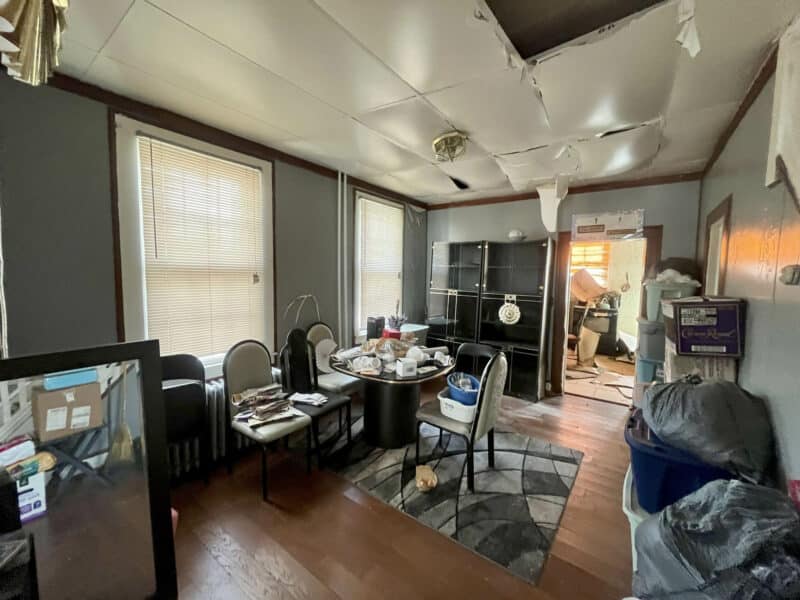 Dining room with hardwood floors and windows, renovation needed.