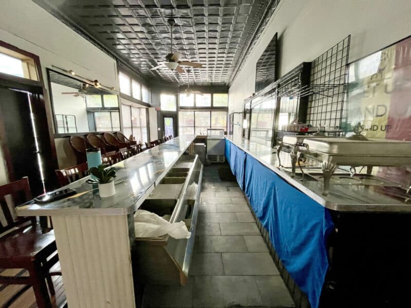 Front service counter and bar setup with stainless steel fixtures and high ceilings.