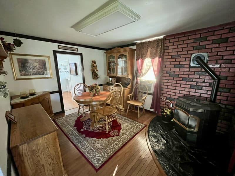 Dining room inside 1207 Joppa Road, featuring wood floors, ceiling fan, and pass-through layout.