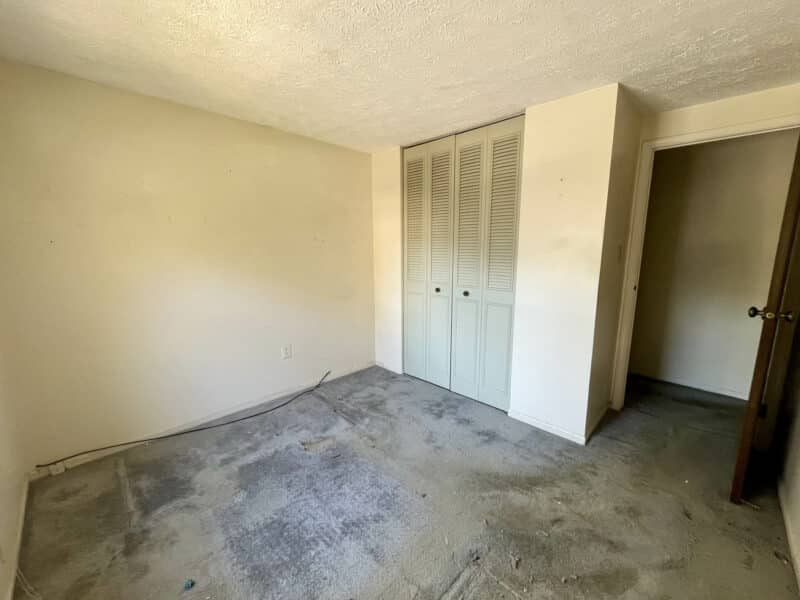 Upstairs bedroom with double-door closet and natural light.