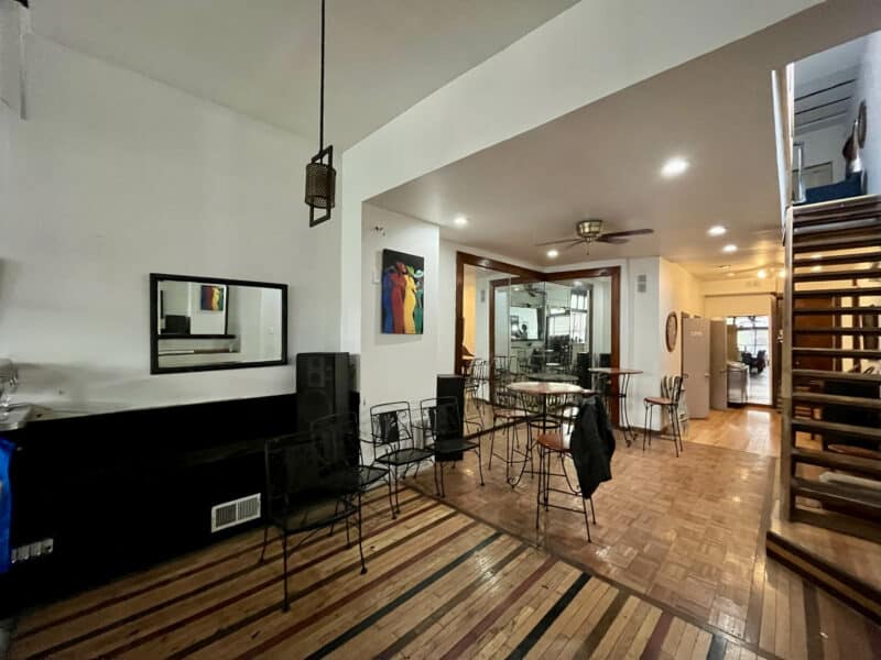 Dining area with wood flooring, pendant lighting, and metal café seating.