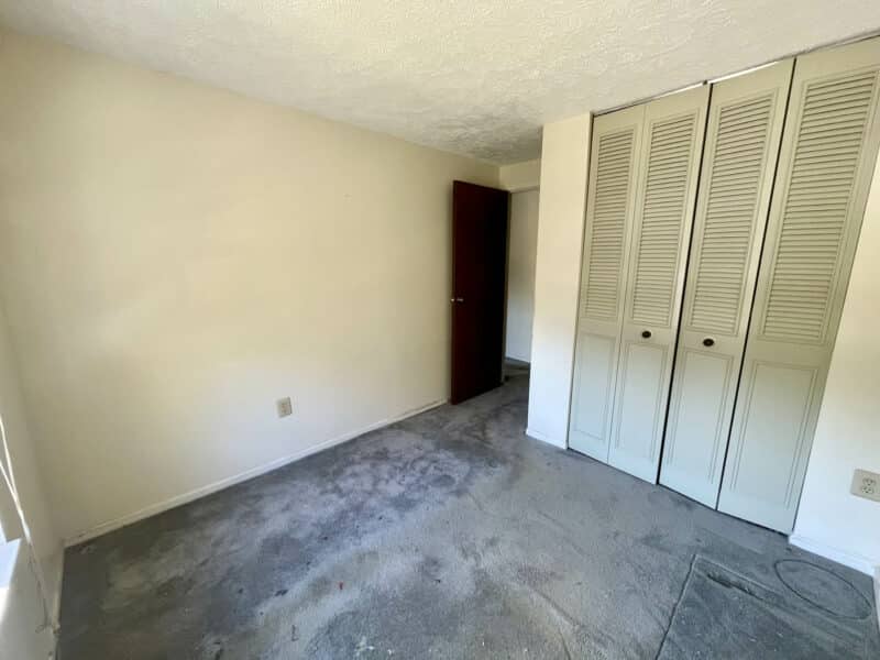 Secondary bedroom with closet and neutral walls.