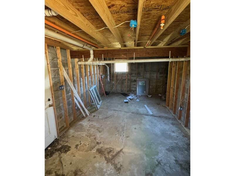 Unfinished basement with exposed framing, subflooring, and mechanical rough-in.
