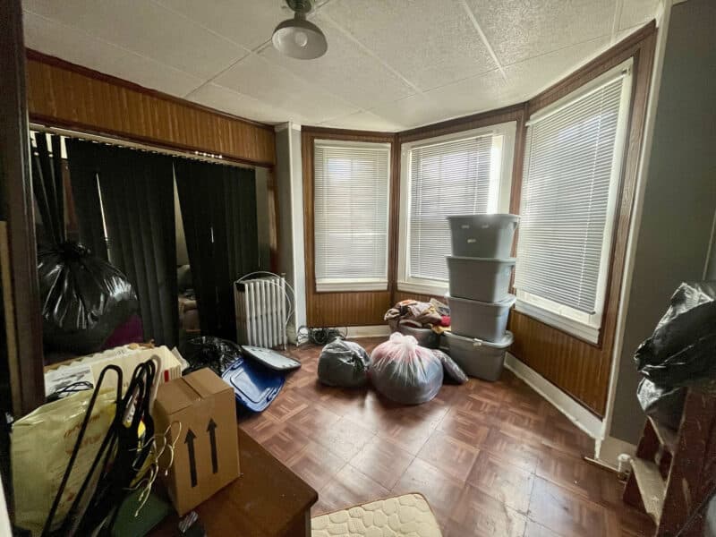 Bay-window bedroom with natural light and laminate flooring.