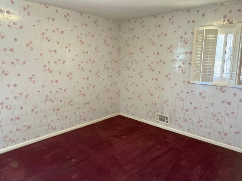 Bedroom with floral wallpaper and red carpet in ranch-style home at 4729 Byron Road, Pikesville.