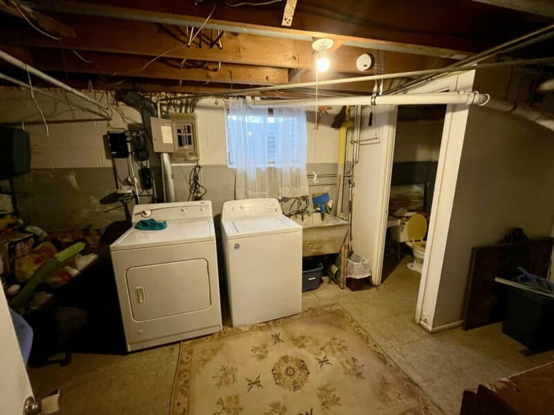 Laundry and utility area in basement with washer, dryer, exposed ceiling and mechanical systems.