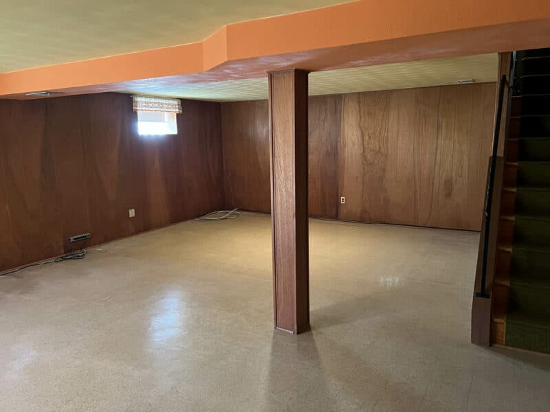 Large basement recreation room with wood paneling and exposed beam ceiling at 4729 Byron Road.