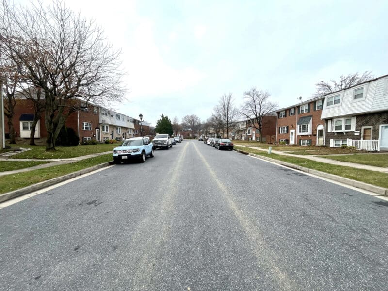 Street view of the residential block on Stormont Circle with rows of brick townhomes and open roadway in Arbutus, MD.