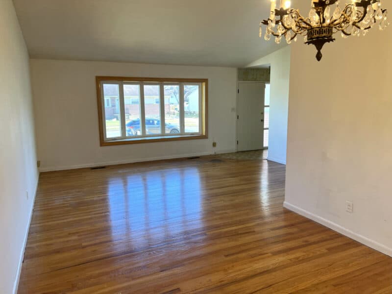 Living room at 4729 Byron Road with hardwood floors, bow window, and open layout to dining area.