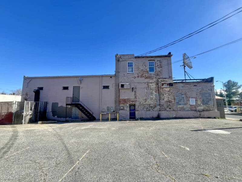 Rear view of the commercial building at 6826–28 Harford Road with paved parking lot and loading access.
