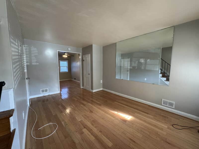 Wide-angle living room photo showing hardwood floors and large front window at 2808 Windsor Avenue.