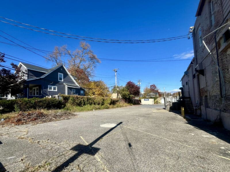 Wide view of rear parking lot behind 6826–28 Harford Road with access to adjoining commercial and residential area.