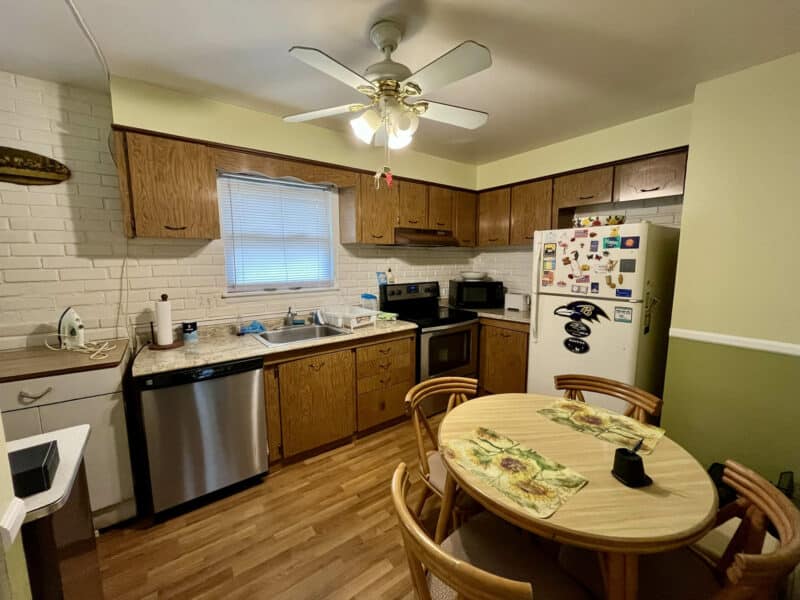 Kitchen with wood cabinetry, laminate flooring, stainless steel appliances, and dining nook at 1014 Stormont Circle.