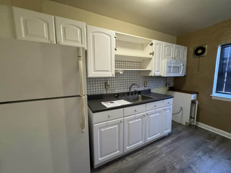 Kitchen at 2808 Windsor Avenue featuring white cabinets, laminate countertops, and tile backsplash.