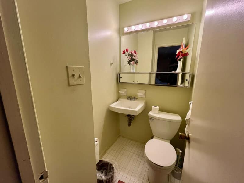 Half bathroom with pedestal sink, toilet, tile floor, and wall-mounted mirror at 1014 Stormont Circle.
