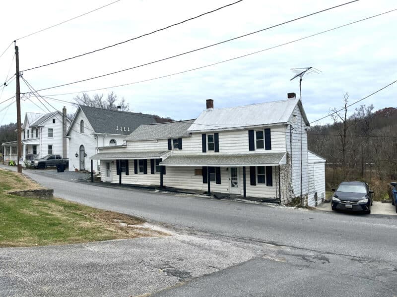 Close front view of the property showing siding, windows, and porch supports.