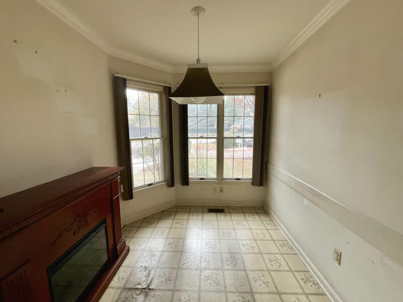 Dining room featuring a large bay window, tile flooring, and a wood-fireplace with decorative mantle.