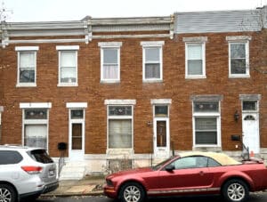Front exterior of 3815 Foster Avenue, a two-story brick townhome in the Brewers Hill neighborhood of Baltimore City