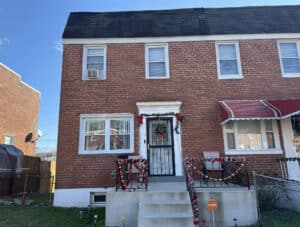 Brick end-of-group townhome with covered front porch and holiday decorations at 4821 Greencrest Road in Baltimore’s Frankford neighborhood.