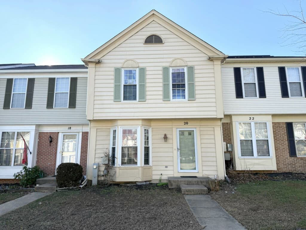 Front exterior view of the two-story townhome at 20 Woodhollow Court in the Pleasant Hills community of Owings Mills, Maryland.