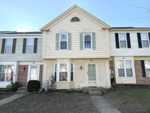 Front exterior view of the two-story townhome at 20 Woodhollow Court in the Pleasant Hills community of Owings Mills, Maryland.