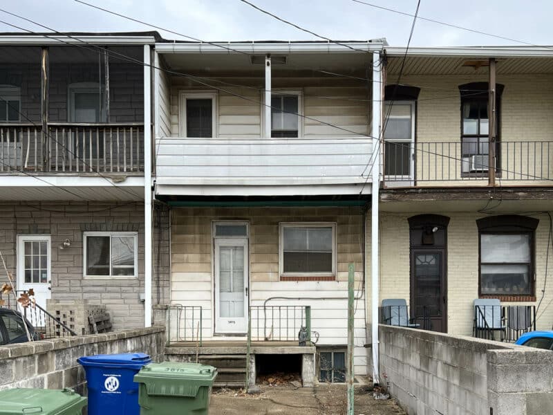 Rear exterior of 3815 Foster Avenue showing concrete parking pad and rear balcony in Brewers Hill Baltimore