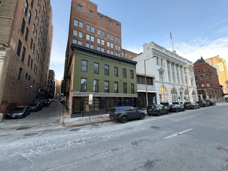 Wide streetscape view showing 8–14 Park Avenue and surrounding downtown Baltimore buildings.