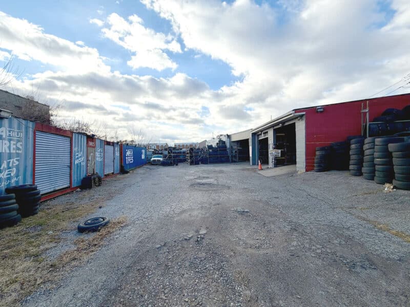 Gravel lot with storage containers and service bays at 3205 E. Madison Street