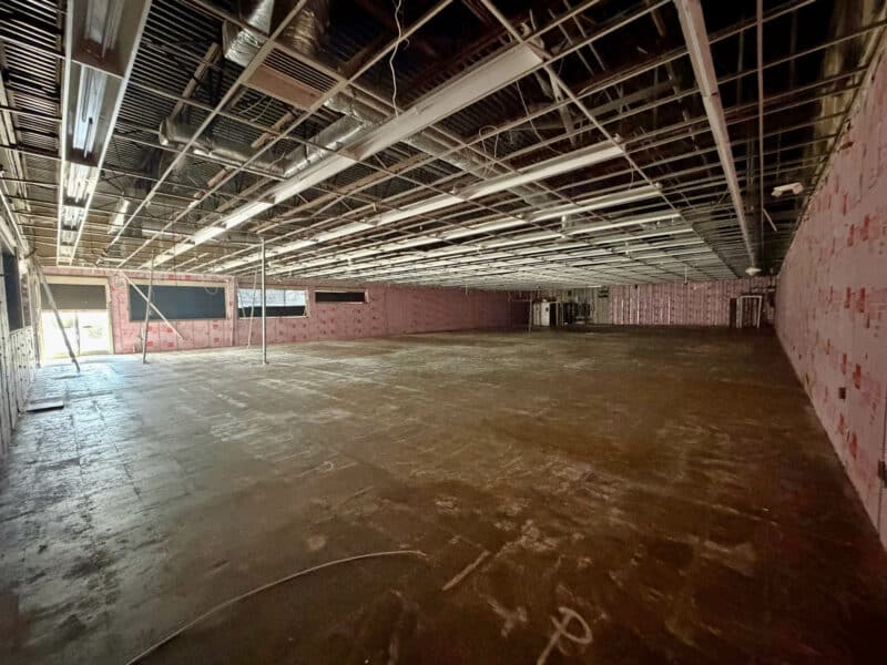 Interior view of vacant retail space at 3615 E. Northern Parkway showing open layout, concrete floors, and exposed ceiling systems.