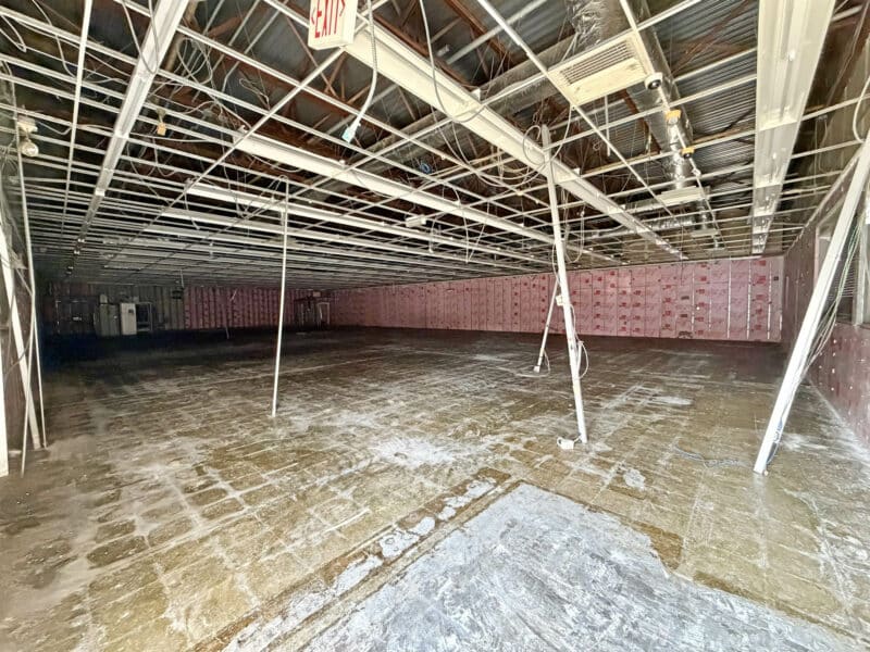 Interior of one-story retail building at 3615 E. Northern Parkway in Baltimore City showing open floor plan, exposed ceiling grid, and concrete slab floor.