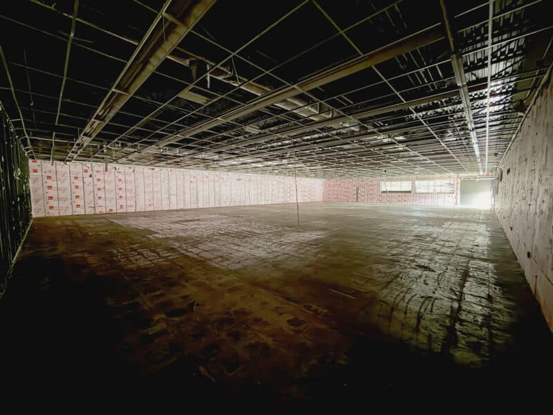Interior of vacant retail building at 3615 E. Northern Parkway showing ceiling grid and open commercial space.