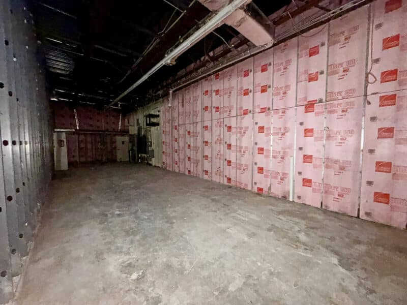 Rear interior section of retail building at 3615 E. Northern Parkway showing unfinished walls and open commercial floor area.